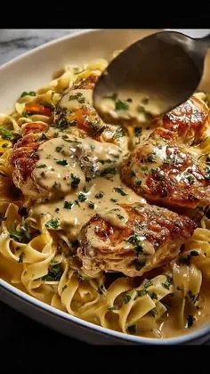 Creamy garlic herb chicken thighs on fettuccine noodles with creamy sauce and fresh parsley.