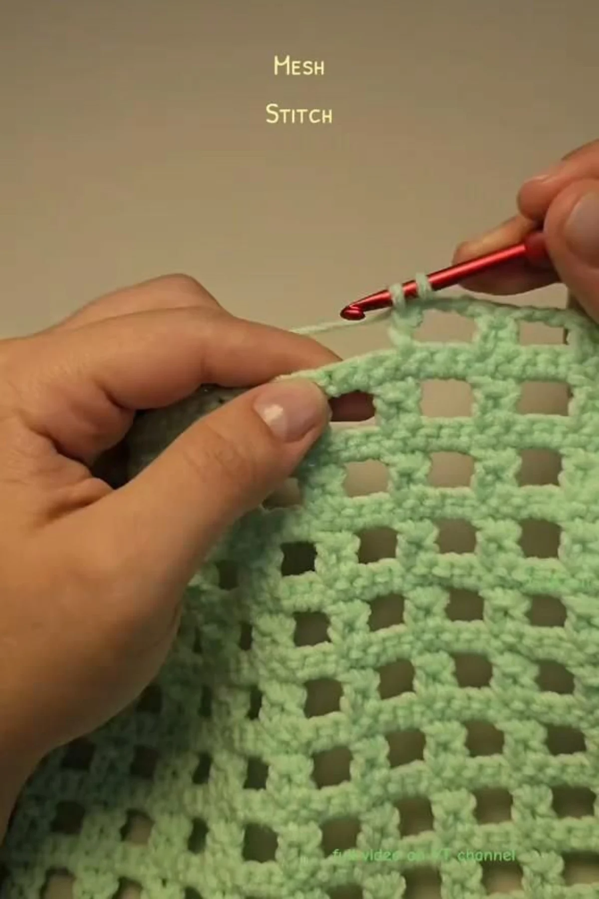 Close-up of crochet mesh stitch fabric showing open lacy holes and neat edges