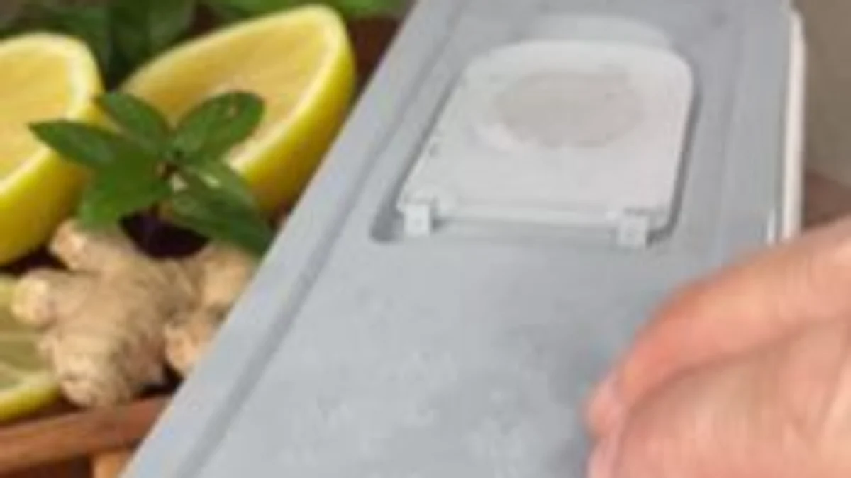 Hand opening a container with a yellowish mixture containing lemon and ginger.