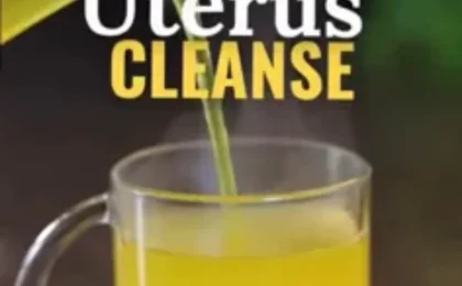 Steam rising from a glass mug of golden ginger lemon turmeric tea with fresh citrus slices and a cinnamon stick on a light.
