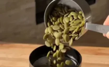 Assorted raw seeds and a glass jar of homemade seed protein powder on a wooden kitchen table