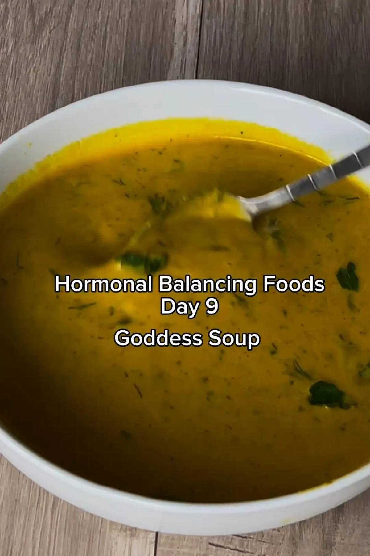 Bowl of hearty vegetable soup with herbs on a wooden table