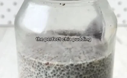 A glass jar of creamy vanilla chia pudding topped with fresh mixed berries and a sprinkle of granola.