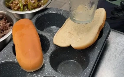 Assembling a Philly cheesesteak with cheese on a hoagie roll in a muffin tin